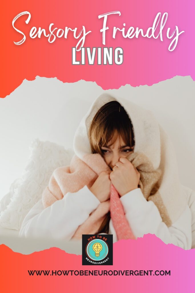 A Pinterest pin image of a woman wearing a sweater and propped up with a pillow with a blanket wrapped around her head and pressed to her face representing sensory friendly living spaces.