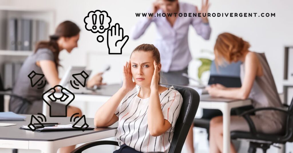 A woman sits at a desk in a loud, busy office space. She has a frown on her face and her hands to her head. Sensory awareness for ADHD and autistic adults.